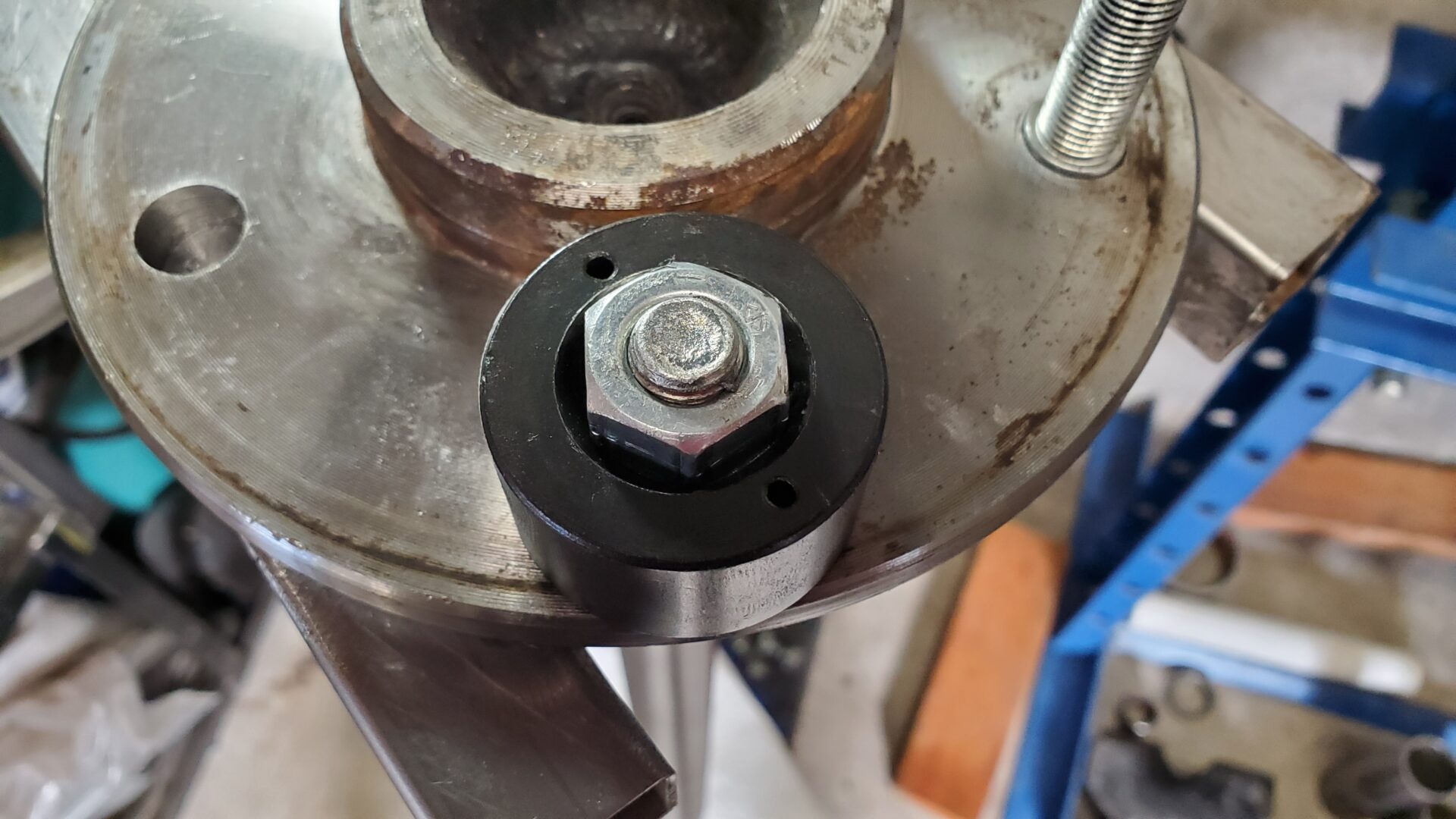 A tapered hole in the tool allows the lug nut to center the stud and keep is straight as it's pulled into the axle. The bearing reduces friction as the nut is tightened and the stud pulled through. 