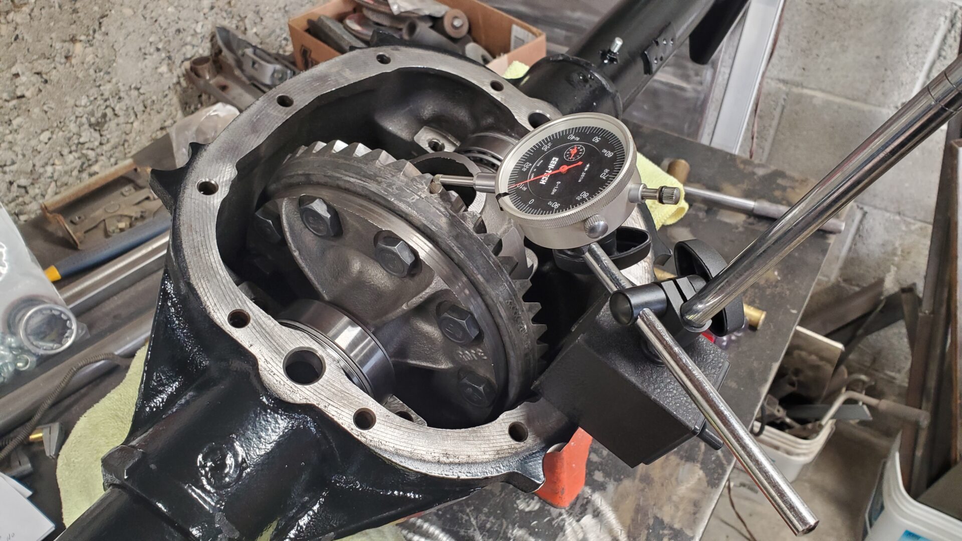 New tapered bearings on either side of the carrier are shimmed to set the backlash between the ring and pinion and bearing preload - or how tight they're squeezed together.  A dial indicator is used to check ring and pinion gear backlash. Specs call for .005"-.009" backlash. We settled on .006"